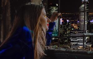 Profile portrait of the beautiful girl with make-up, among the beautiful city with the colorful lights, at the night