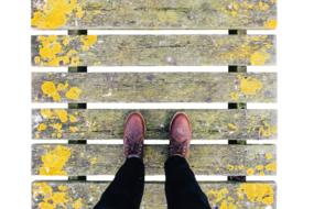 man's feet in boots on the boardwalk