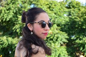 girl in sunglasses in nature on a blurred background