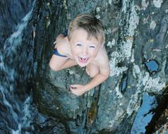 boy is standing in a mountain river