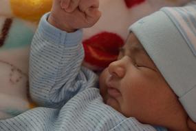 newborn in a blue suit sleeps