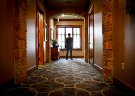 Man, in the beautiful and colorful hall, looking into the window with light