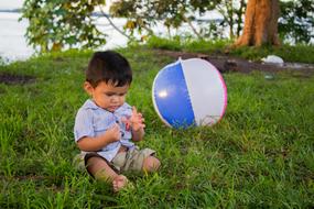 little kid with a ball in the background