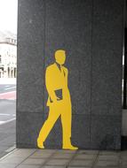 Yellow painting of the man in suit, on the wall on the street