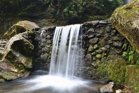 The waterfall with the rocks is beautiful.