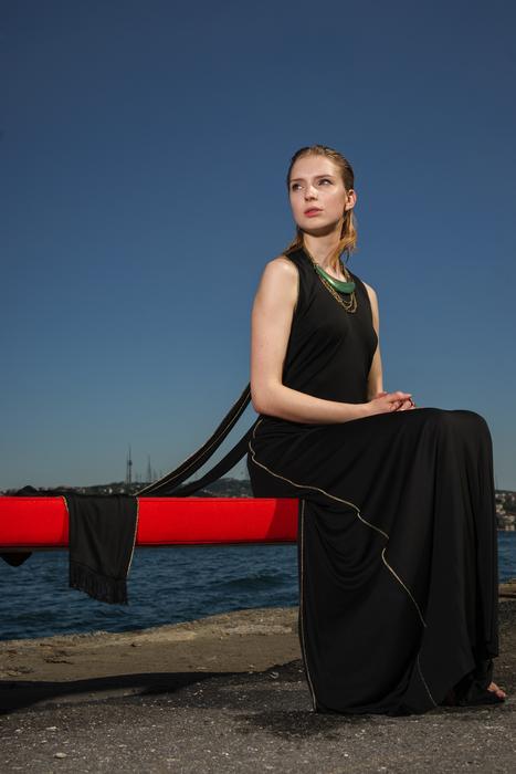 woman in a black dress by the sea