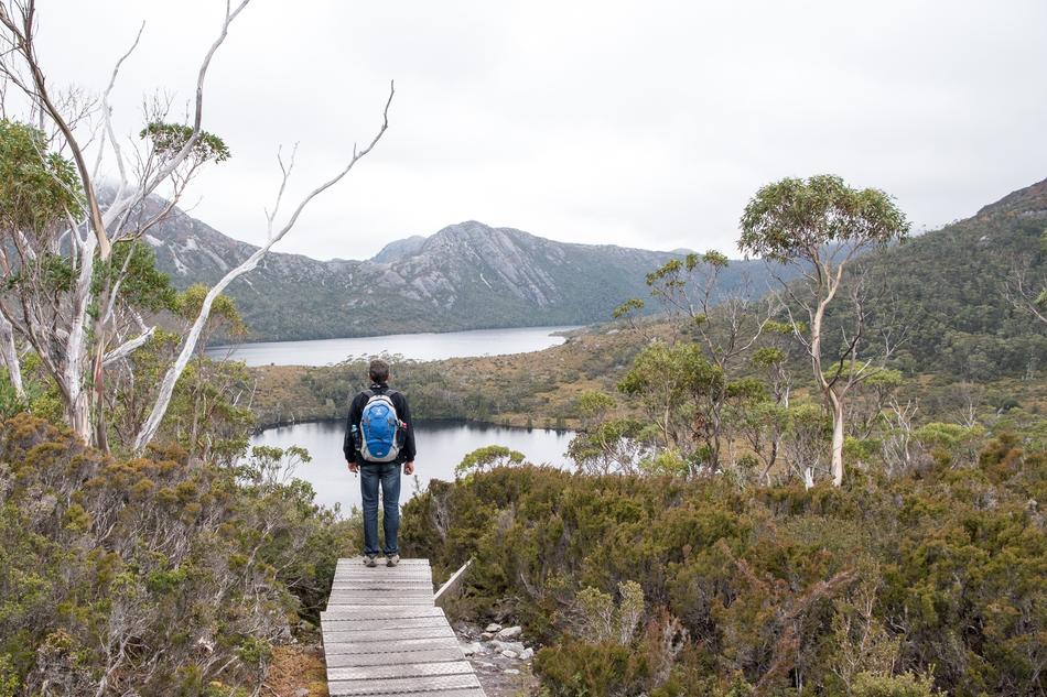 a man with a big backpack in the countryside by the lake