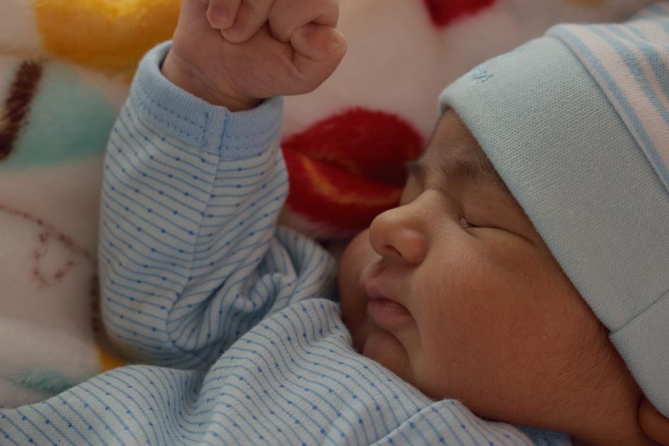 newborn in a blue suit sleeps