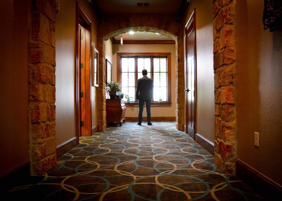 Man, in the beautiful and colorful hall, looking into the window with light