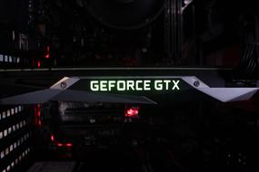 Close-up of the beautiful Geforce Gtx video card, with the green sign, among the darkness