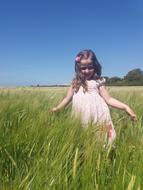 happy girl walking in a summer meadow