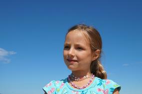 portrait of child Girl with beads on neck at Sky