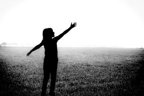 black silhouette of a girl in the field