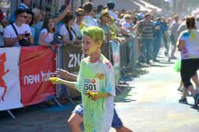 Boy and other people, in the colorful paint, on the festival in Kiev, Ukraine