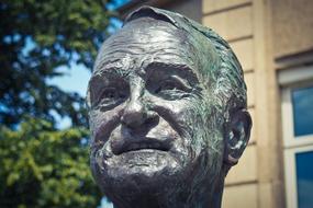Bust of Johannes Rau, near the green trees and building, in Germany