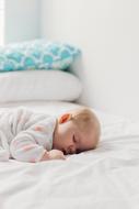 newborn baby sleeping in bed