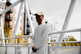 man in a striped shirt on a white bridge in the city