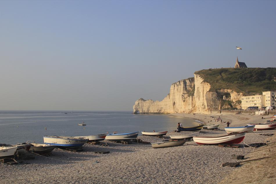 sea beach with boats and lighthouse