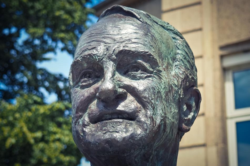 Bust of Johannes Rau, near the green trees and building, in Germany