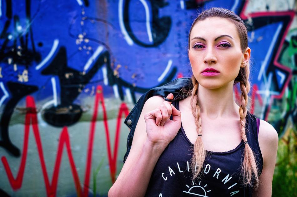 girl with pigtails near the wall with graffiti