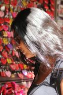 Girl with the shiny hair, and in sunglasses, near the colorful stuff