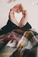 heart made of snow in human hands