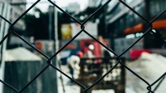 photo of a construction site through a metal mesh