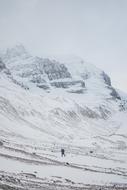 distant view of hiker in snowy mountains