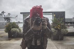 girl with Canon Camera at face outdoor, view through dirty glass