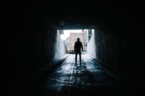 photo of a man in a dark tunnel