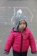Baby Girl in funny hat and pink jacket
