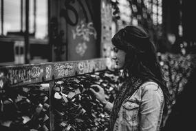 Beautiful sad girl at fence with love locks