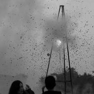 Black and white photo of the explosion, with the debris, and people