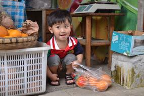 little boy with oranges at the market in china