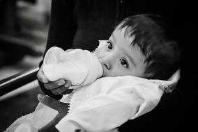baby with milk bottle in black and white background