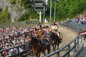 horse riders among people in open air theater