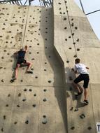 People, climbing on the wall, with the ropes, outdoors