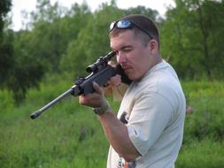 Man, with the glasses and riffle, among the green plants