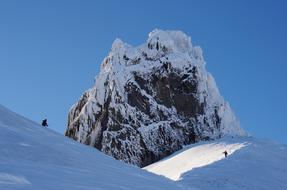 a big rock in the snow on the mountain