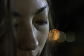 Portrait of the girl with closed eyes, at background with colorful bokeh lights