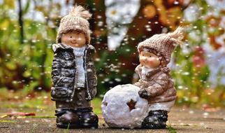 funny figurines of children in winter on a blurred background