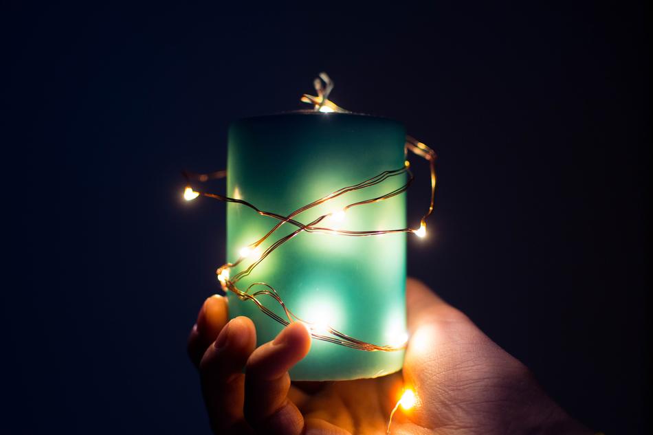 light green candle in hand close-up