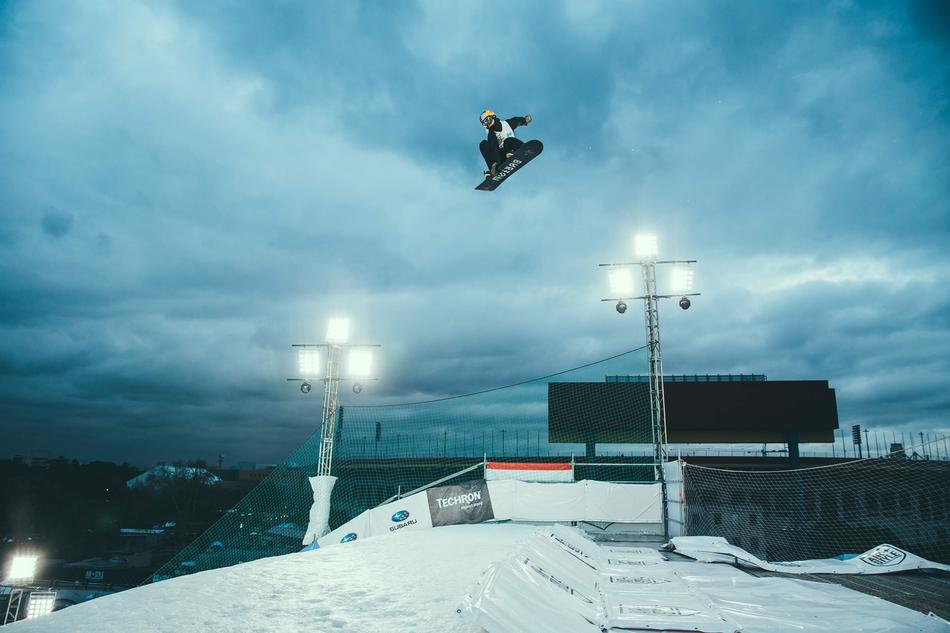 flight of a snowboarder against the background of spotlights on the slope