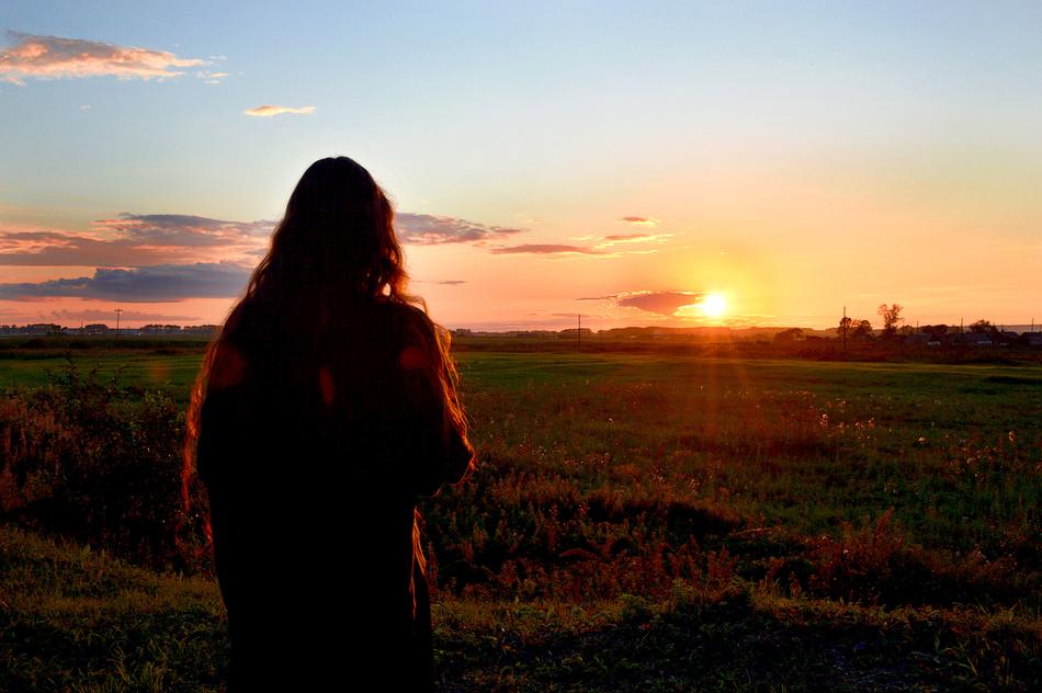 a girl at sunset in a field