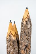 three large wooden pencils on a white background