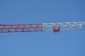 red and white crane boom against the blue sky