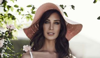 Portrait of the beautiful girl in floppy hat, near colorful and beautiful tree with the flowers