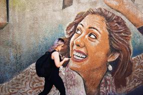 girl near wall with woman art