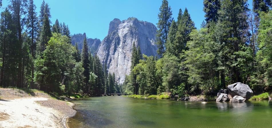 a beautiful landscape of mountains and a lake in the forest