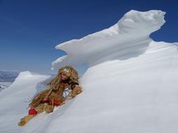 funny doll lies on a snowdrift